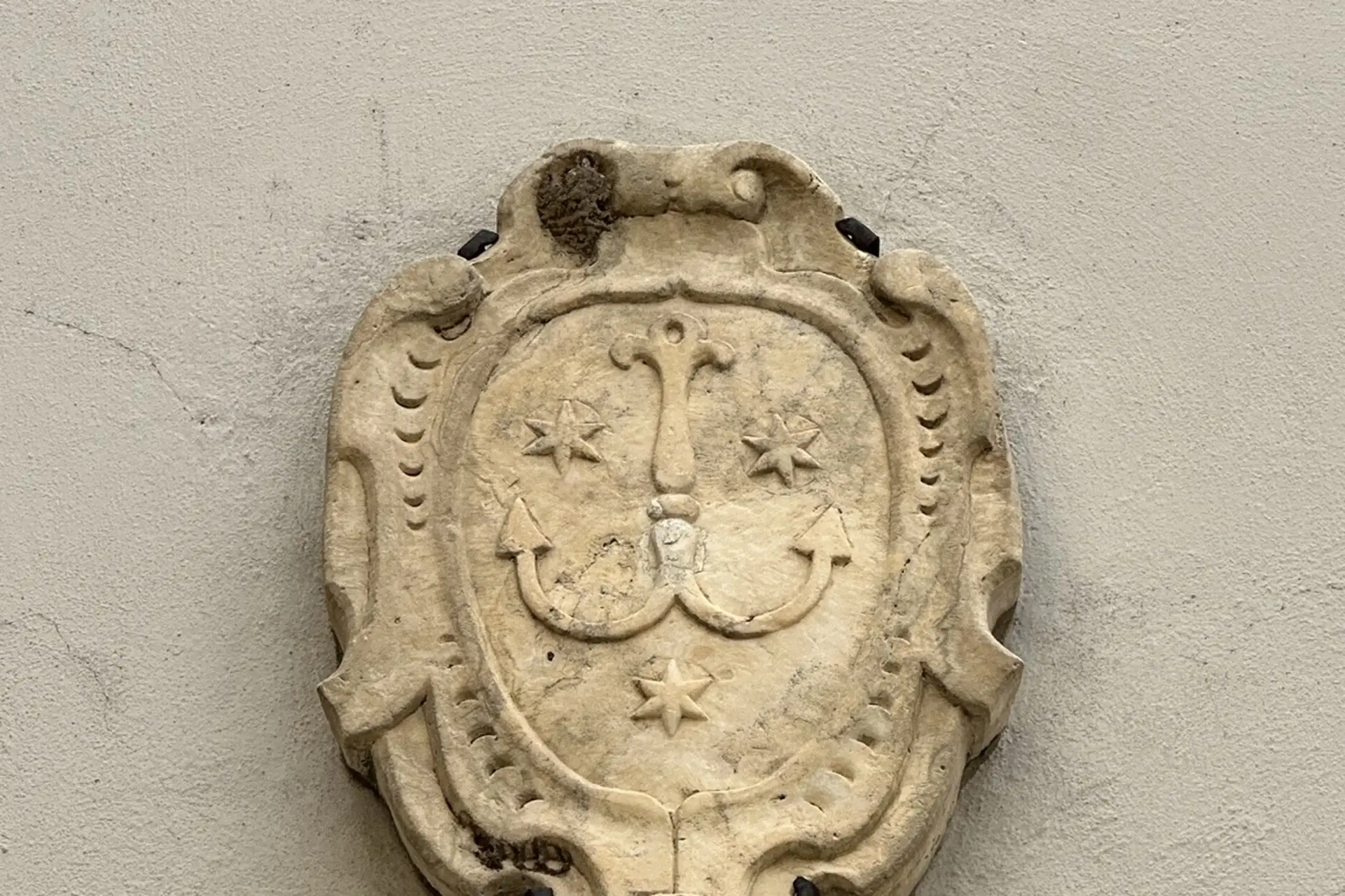 Tamanti arms above the main entry: anchor and three eight-pointed stars in a scrolled cartouche
