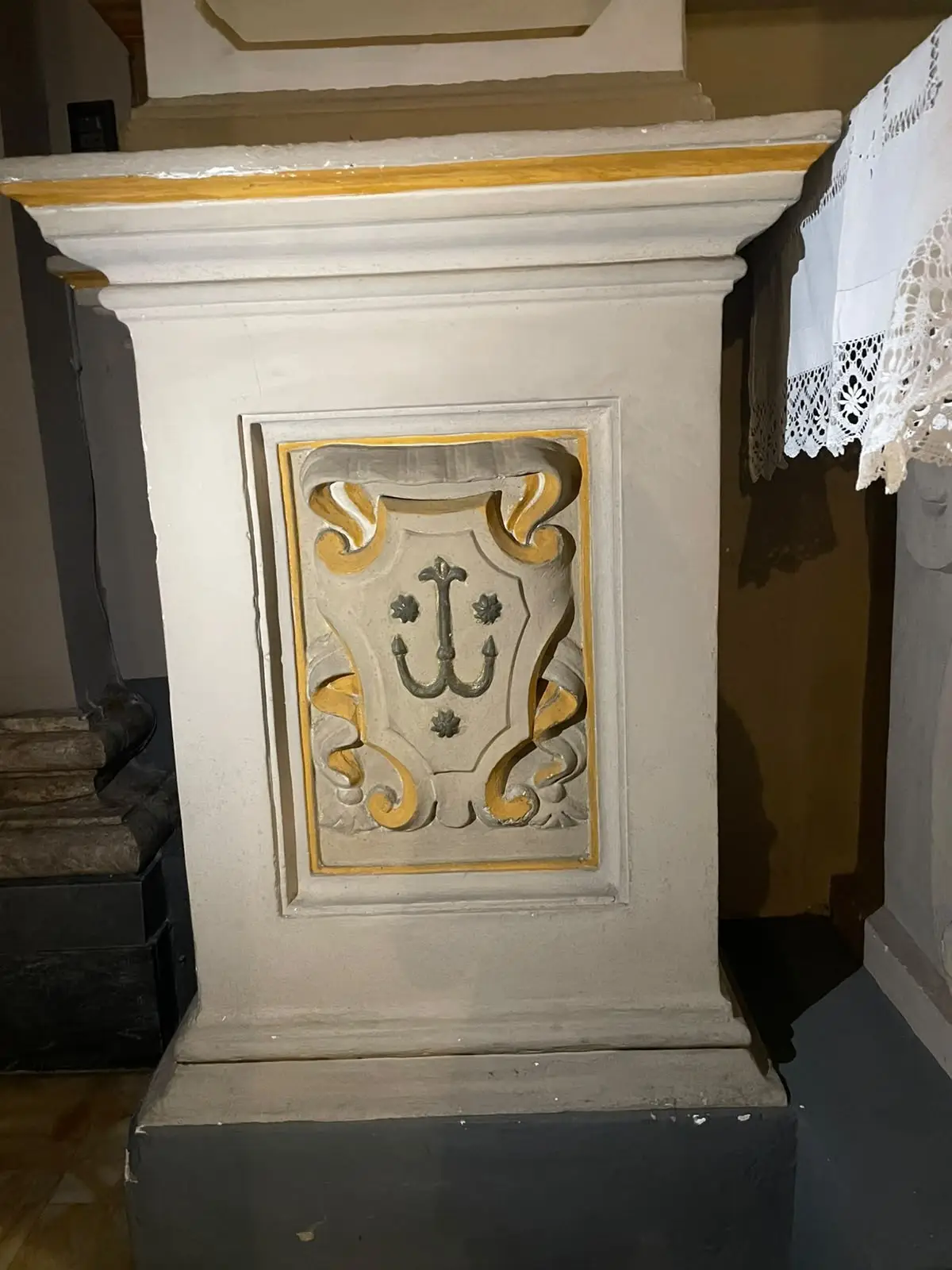 Tamanti anchor-and-three-stars relief inside Madonna del Soccorso, Montalcino (photographed August 2026)
